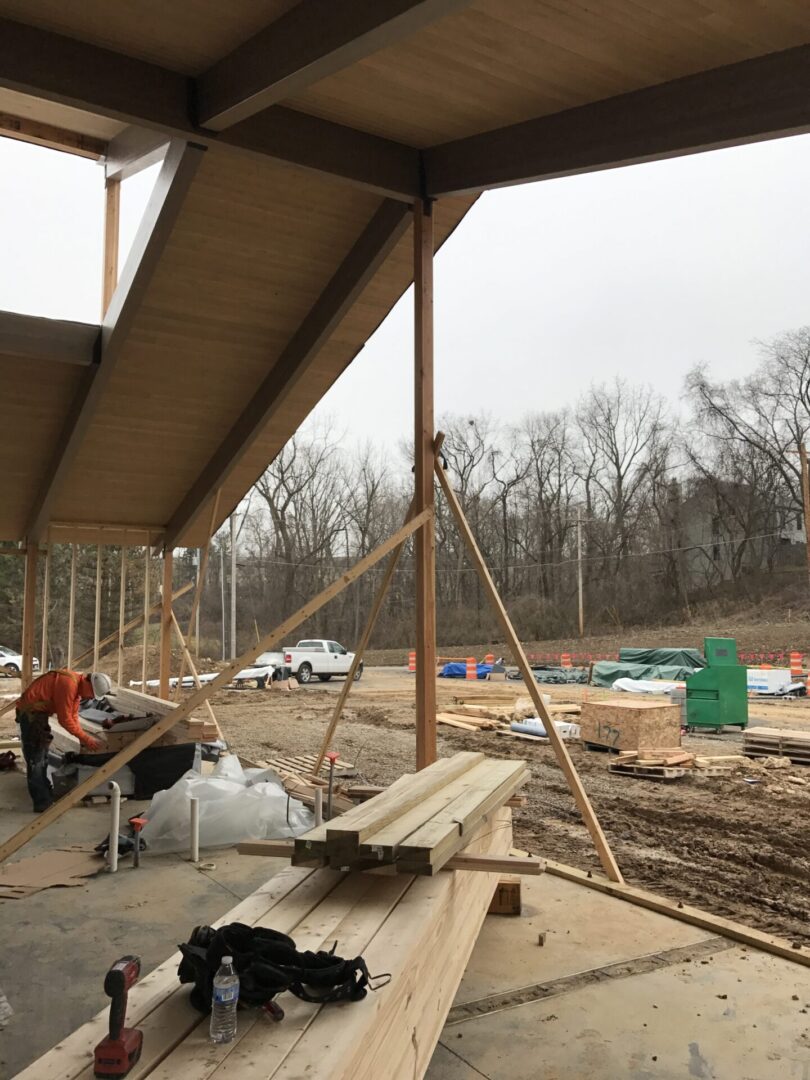 Man working on a wooden structure in the middle of a construction site