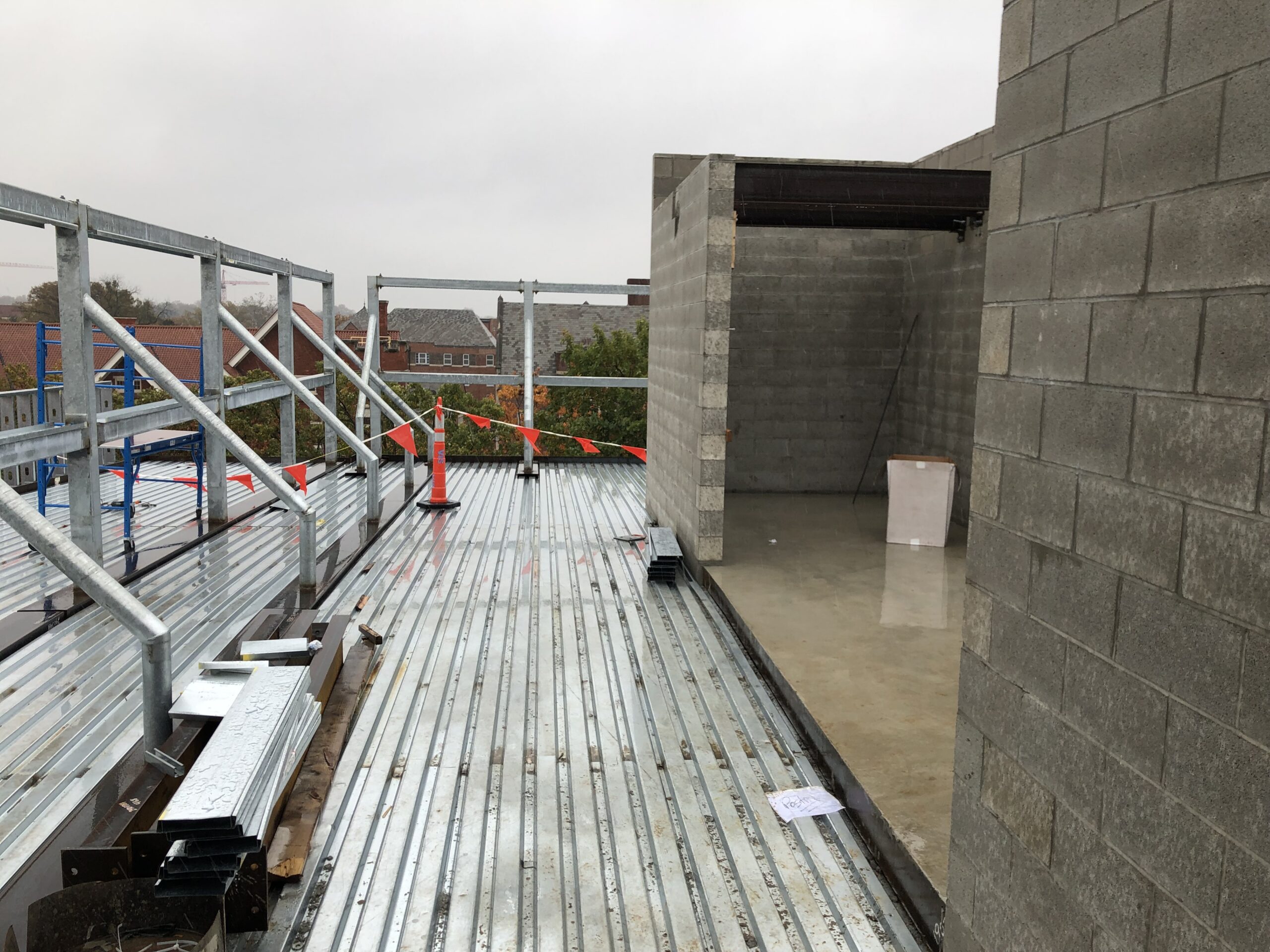 Building under construction with a metal roof and a concrete wall