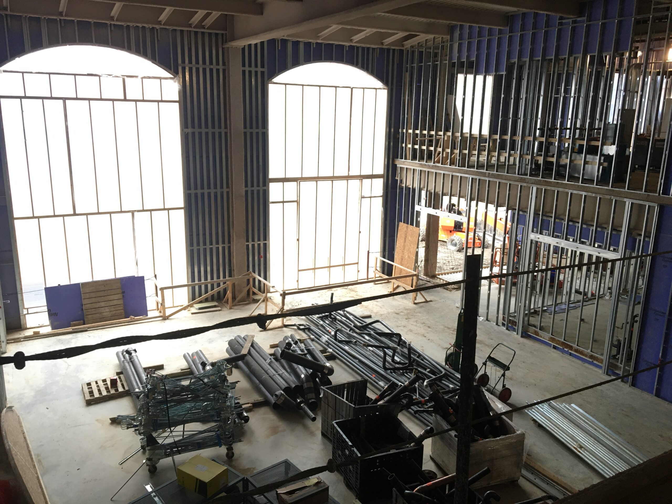 Large room filled with lots of metal rods, machines, boxes, and other objects on the floor