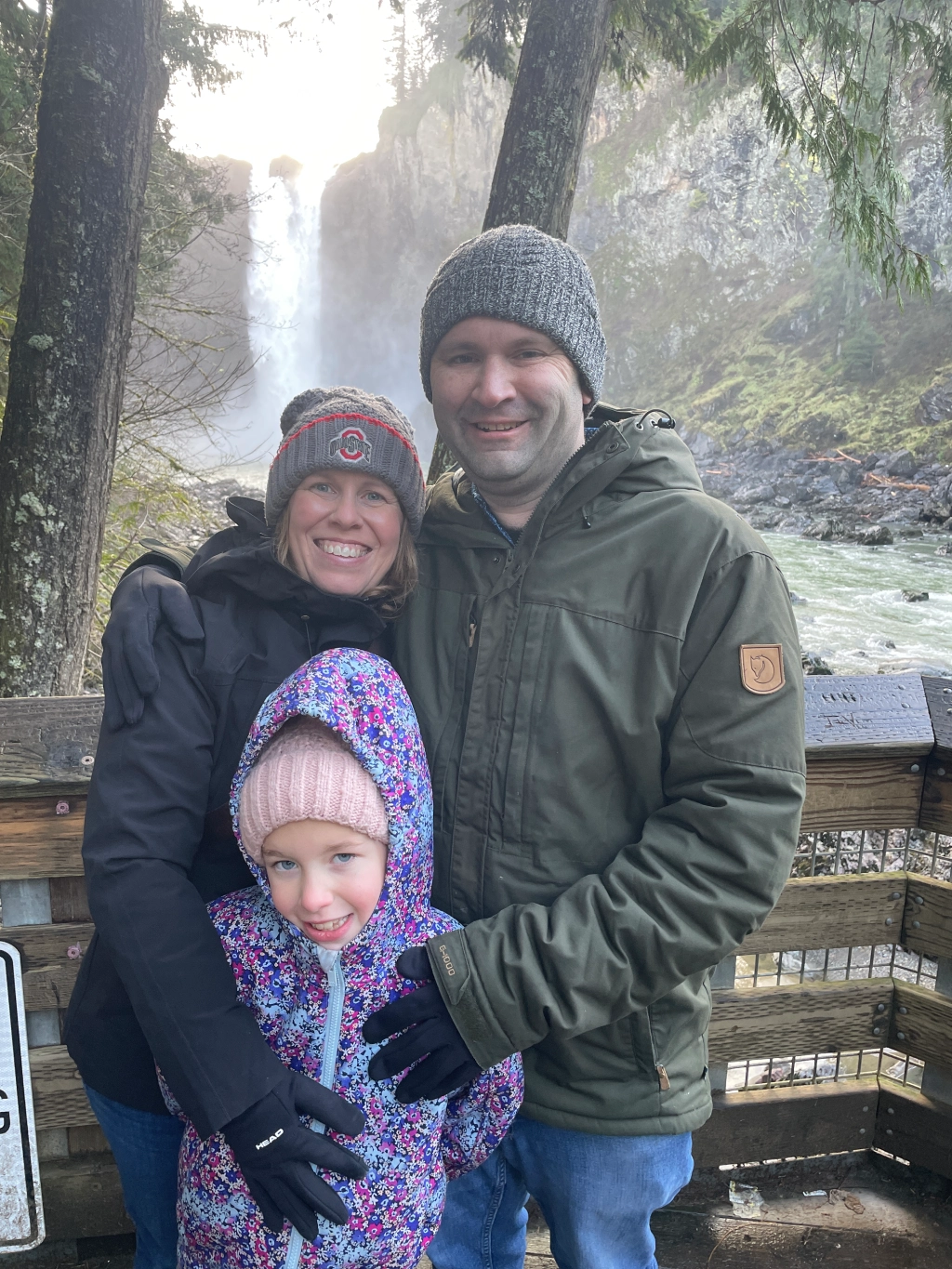 Man and woman standing in front of a waterfall, and posing for a photo