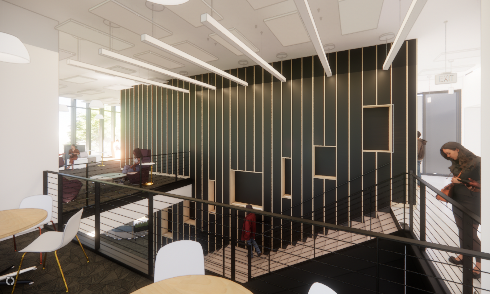Room with tables and chairs, a railing, a wall with a door, lights on the ceiling, and a few people